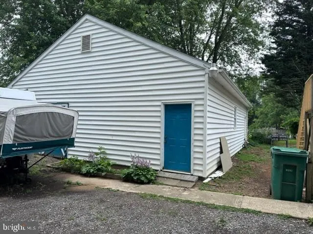 a view of a white house with a small yard and a large tree