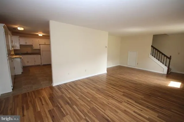 a view of a room with wooden floor and a window
