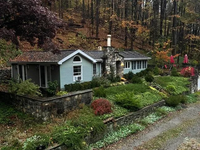 a front view of house with a yard and green space