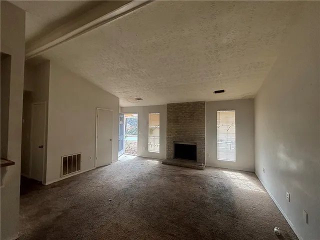 a view of empty room with a fireplace
