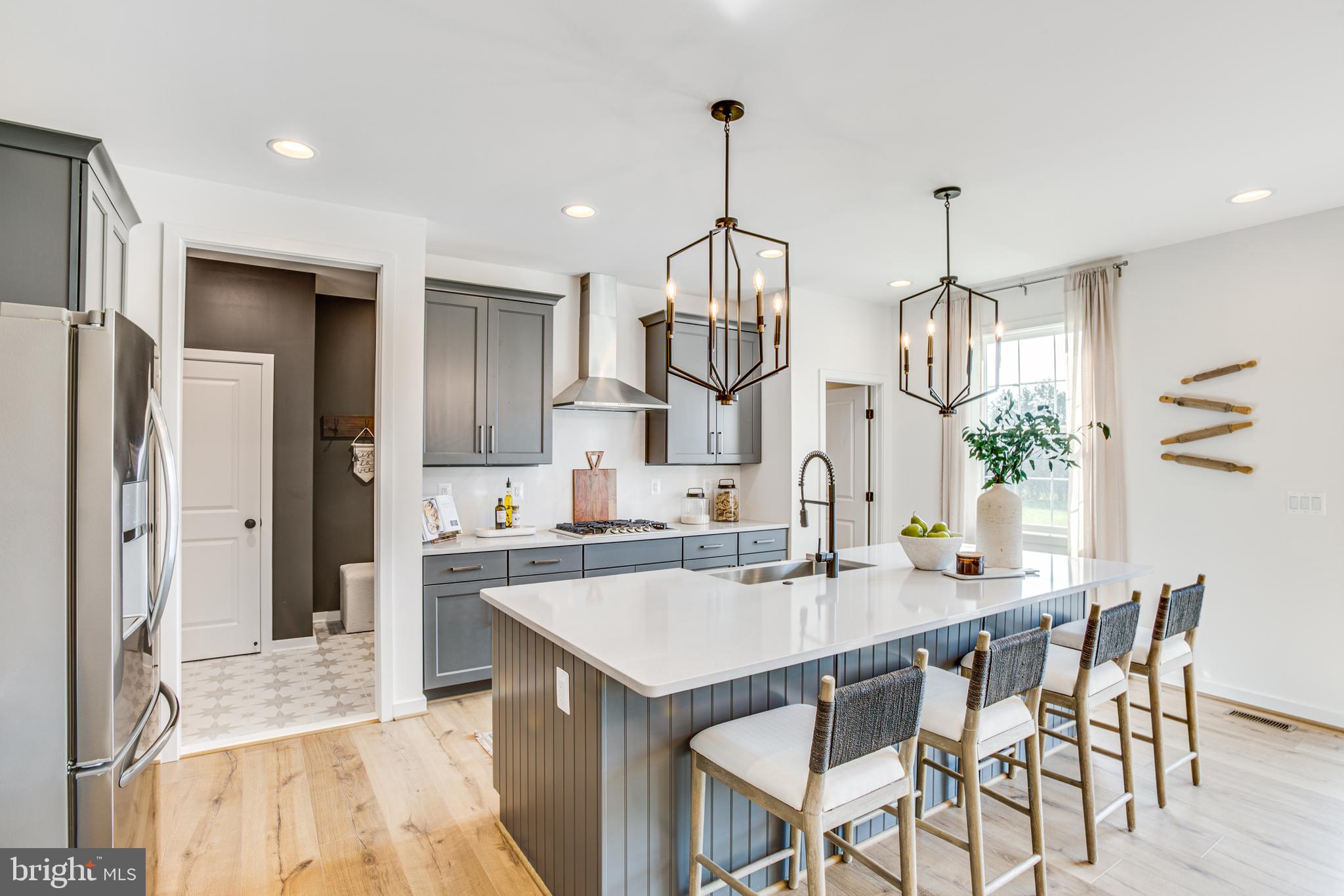 9 Burwell Road Nokesville, VA 20181 - Photo 14 of 61 a kitchen with stainless steel appliances kitchen island granite countertop a table chairs in it and white cabinets