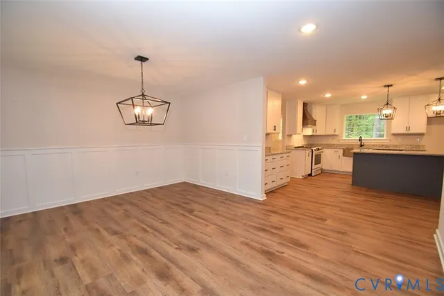 a view of a kitchen with a sink a refrigerator and wooden floor
