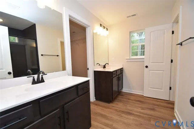 a bathroom with a sink double vanity granite tub shower and a mirror