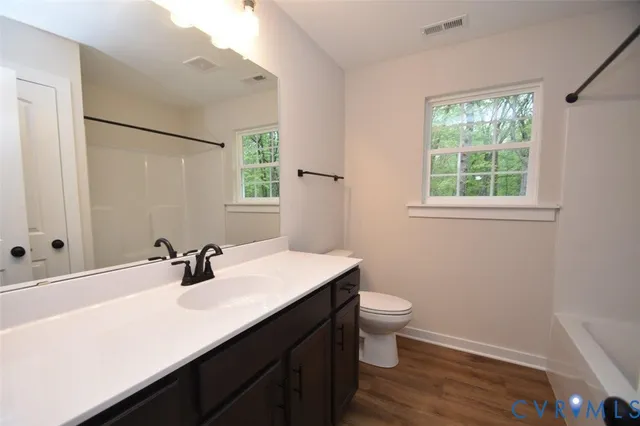 a bathroom with a sink a toilet a window and mirror