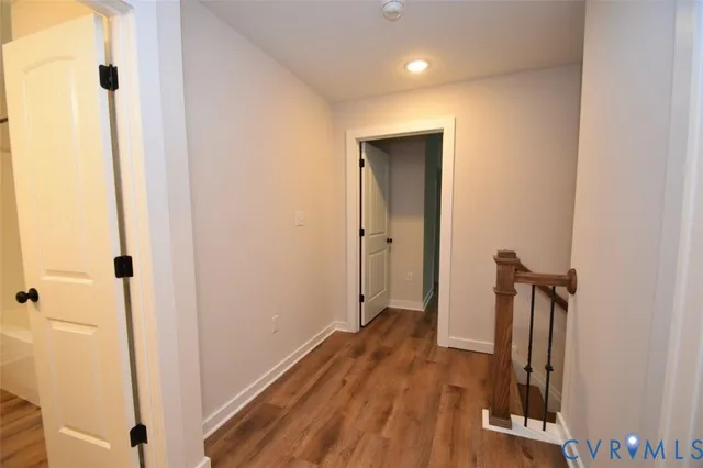 a view of a hallway with wooden floor and staircase