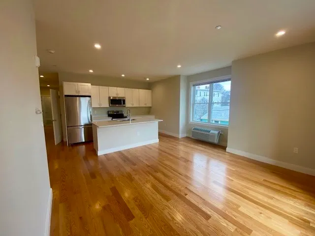 a view of a kitchen with a sink and a refrigerator
