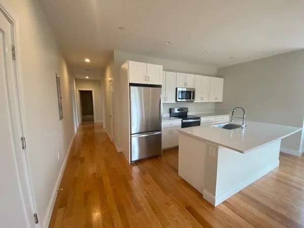 a kitchen with stainless steel appliances a refrigerator and a stove top oven
