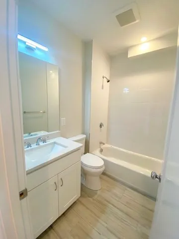 a bathroom with a double vanity sink toilet and shower