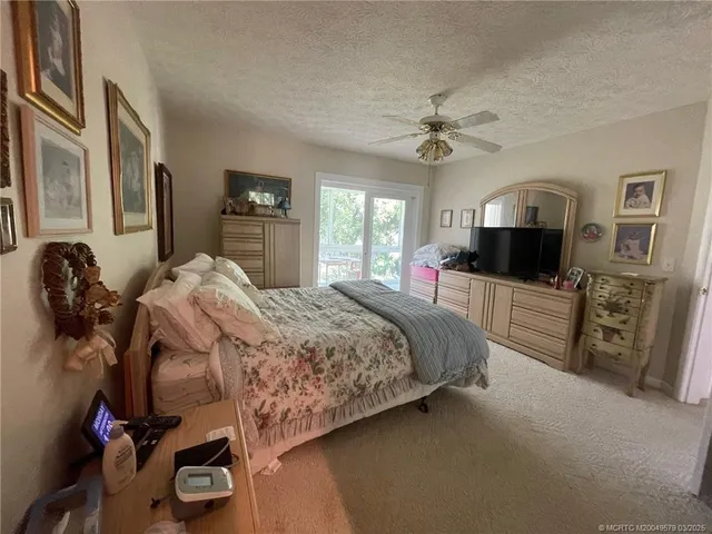 a bedroom with a bed and a flat tv screen on the dresser