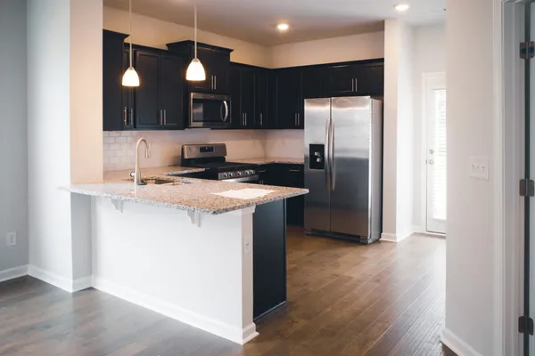 a kitchen with kitchen island a counter space a sink and a refrigerator