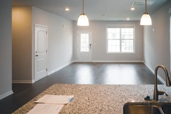 a kitchen with a sink chandelier and wooden floor
