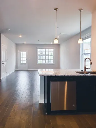 a kitchen with a sink a window and wooden floor