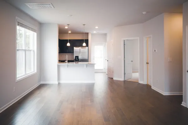 a view of a big room with wooden floor and a window