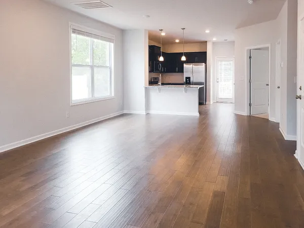 a view of a big room with wooden floor and a window