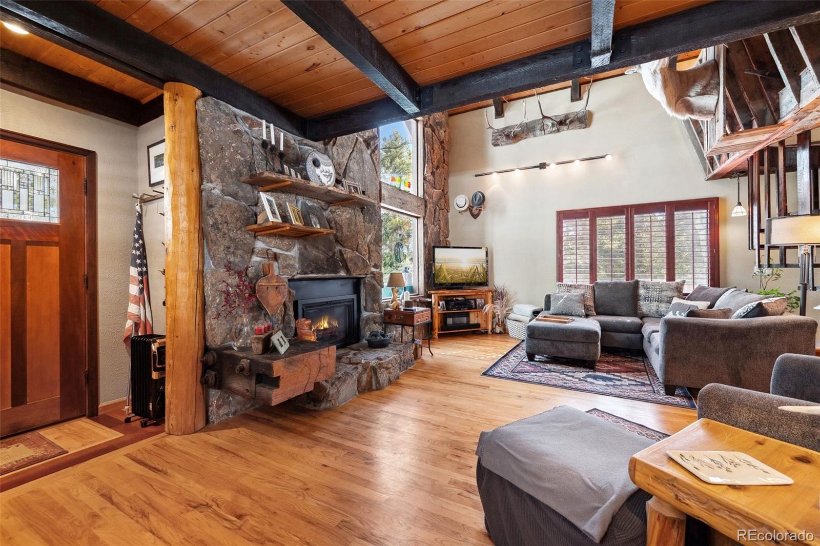 266 Lodgepole Drive Evergreen, CO 80439 - Photo 14 of 45 a living room with furniture a fireplace and a large window
