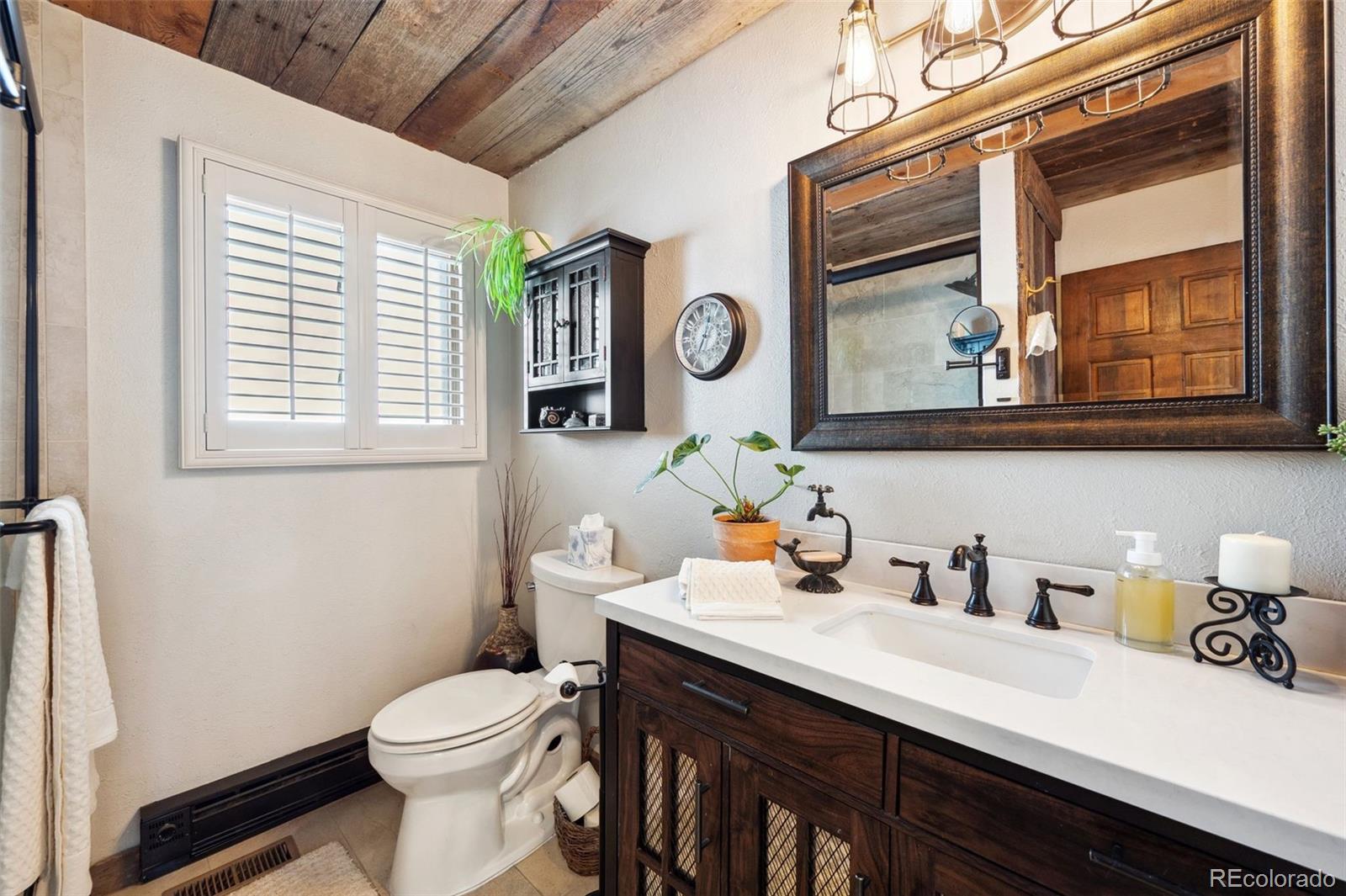 266 Lodgepole Drive Evergreen, CO 80439 - Photo 26 of 45 a bathroom with a sink a toilet and a window