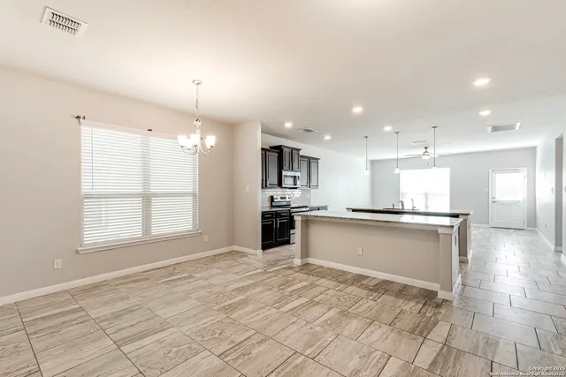 a large kitchen with kitchen island a sink stainless steel appliances and cabinets