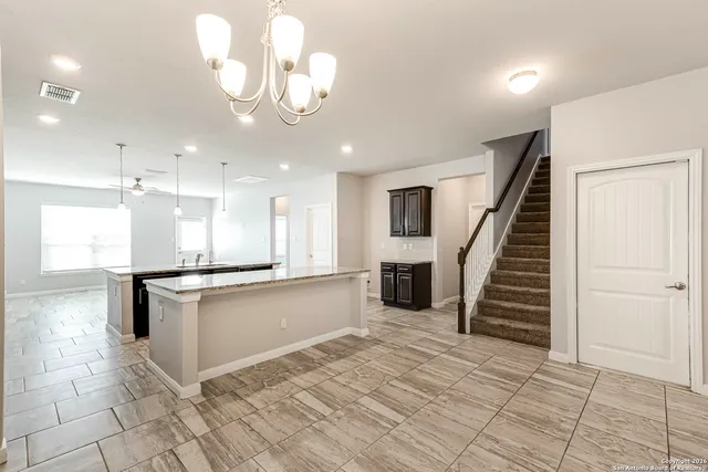 a large kitchen with stainless steel appliances kitchen island granite countertop a sink and cabinets