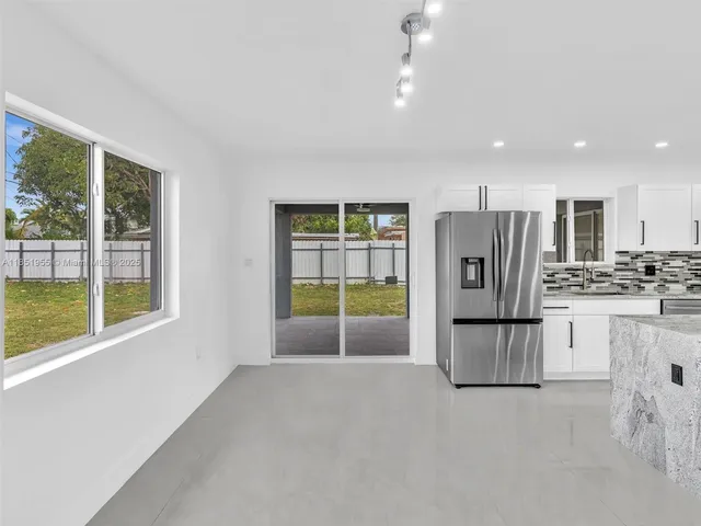 a large white kitchen with stainless steel appliances