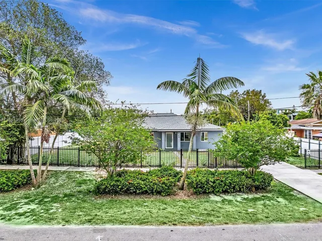 an aerial view of residential houses with outdoor space and trees
