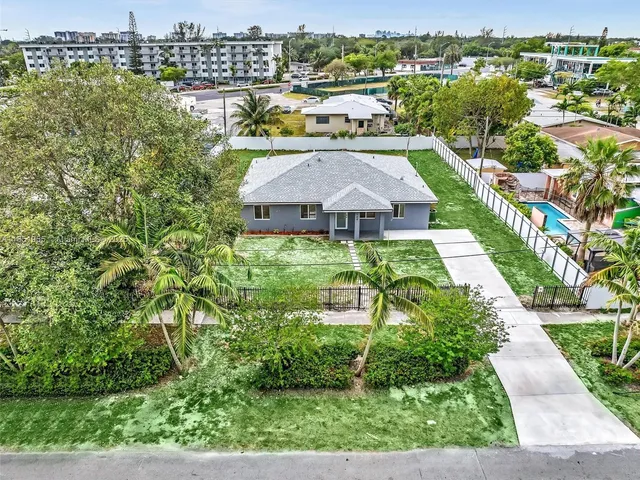 an aerial view of a house with a yard and a fence
