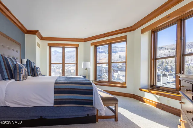 a bedroom with a bed and a large window with outer view