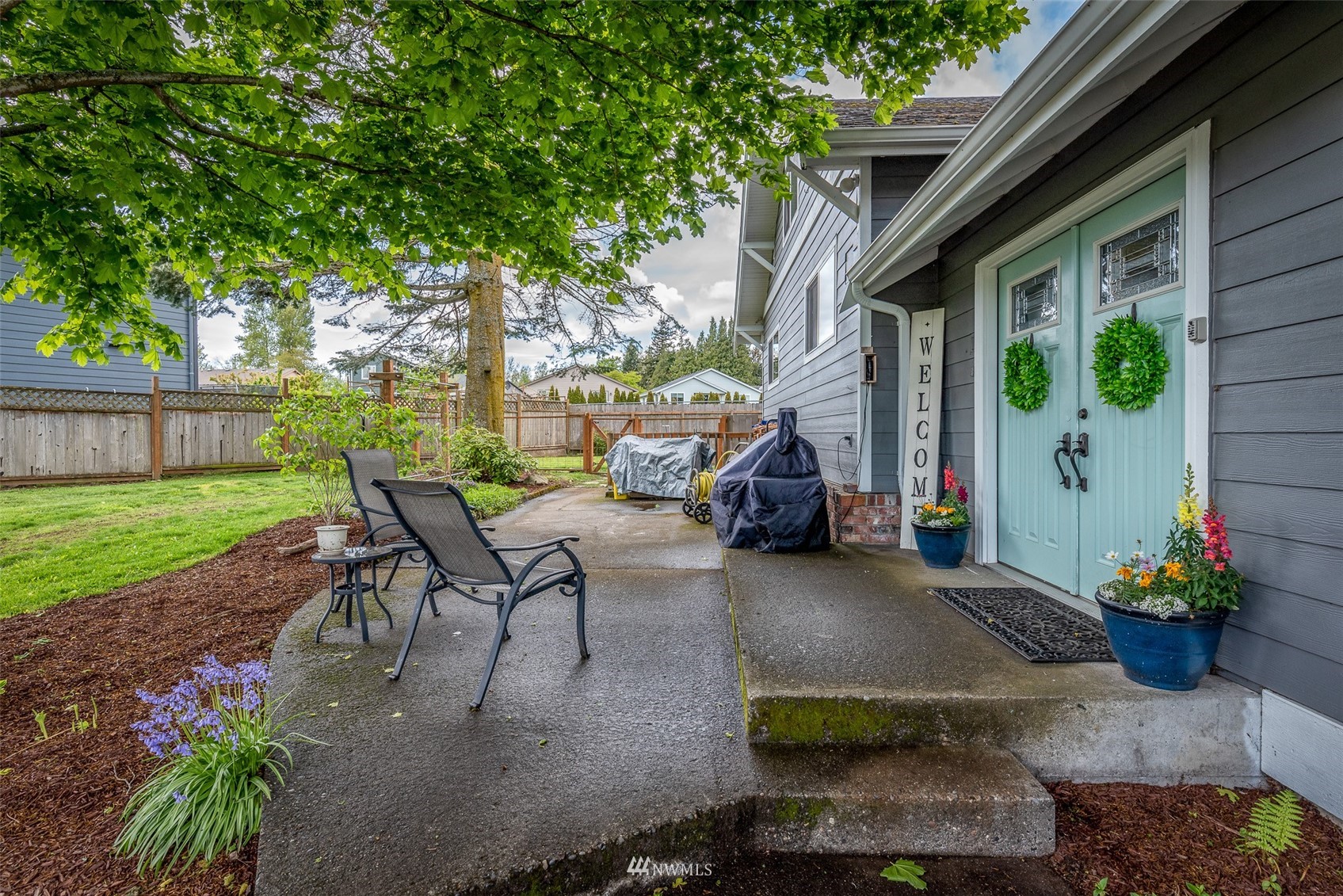 6093 Captain's Way Ferndale, WA 98248 - Photo 31 of 32 a view of a patio with table and chairs potted plants and large tree
