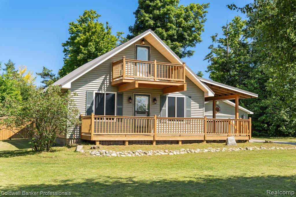 6389 Postlewait Road Mancelona, MI 49659 - Photo 5 of 50 Gable-roof property featuring siding, a front deck, an upper-level balcony, and a covered side porch