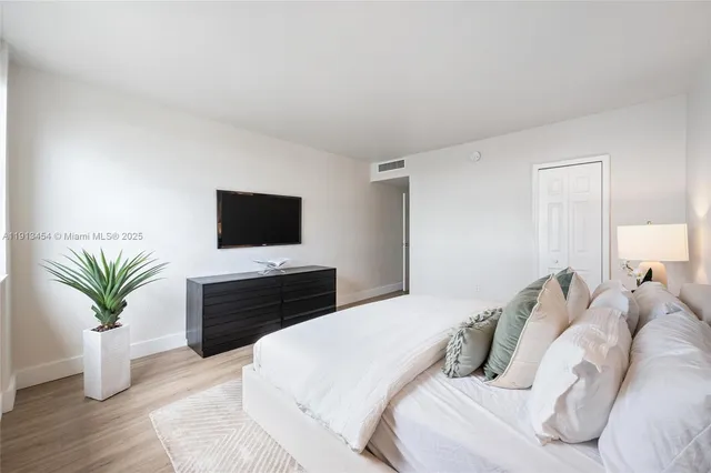 a bedroom with a bed and a flat screen tv