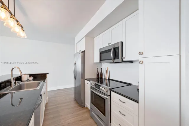 a kitchen with a sink and steel appliances