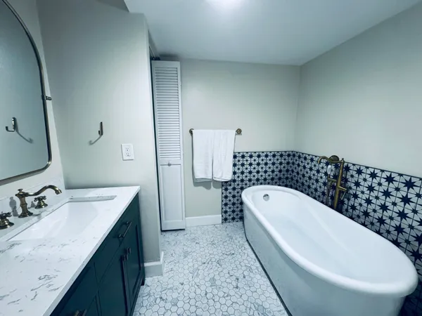 a spacious bathroom with a double vanity sink mirror and bathtub