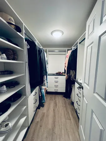 a view of walk in closet with clothes and shoes