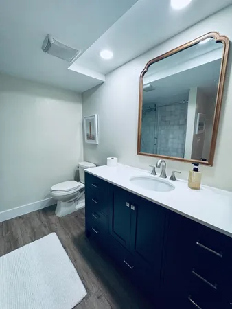 a spacious bathroom with a toilet sink and mirror