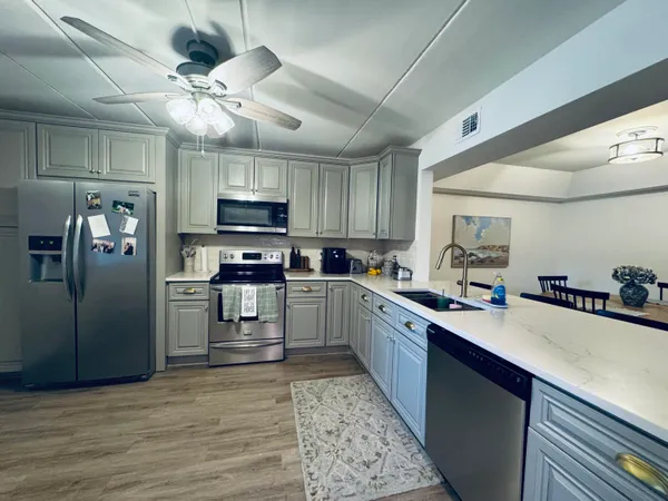 a kitchen with granite countertop a refrigerator stove top oven and sink