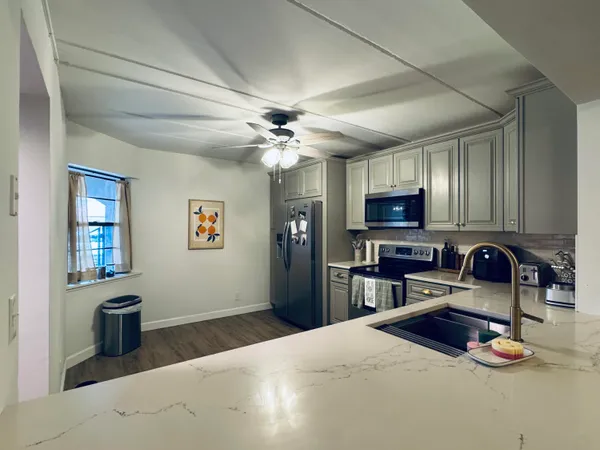 a kitchen with stainless steel appliances granite countertop a sink dishwasher stove and refrigerator
