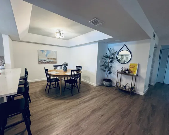 a view of a a dining room with furniture window and wooden floor