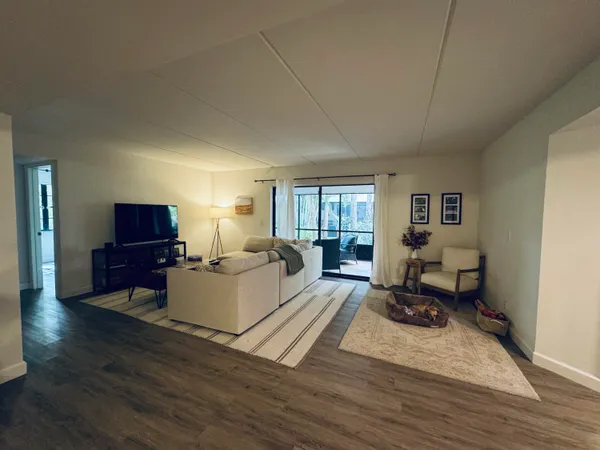 a living room with furniture wooden floor and a window