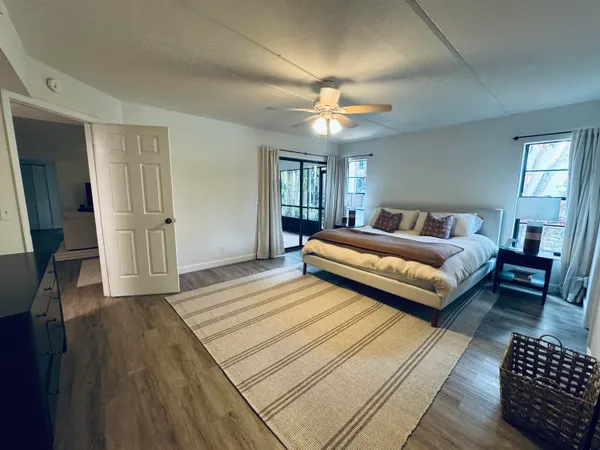 a spacious bedroom with a bed a couch and a chandelier