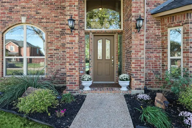 a view of a brick house with potted plants