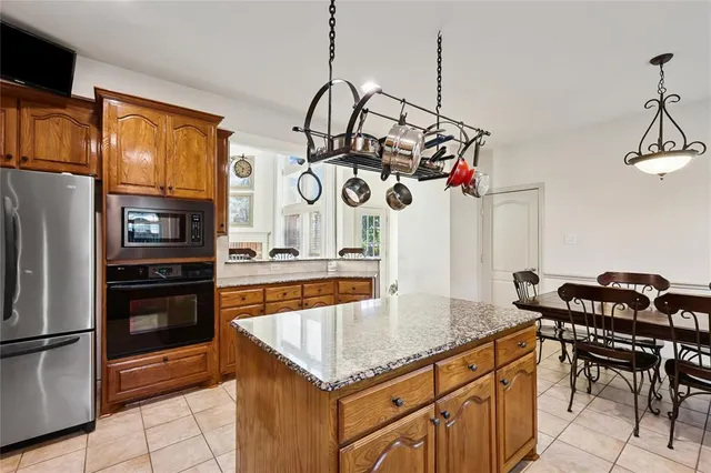 a kitchen with stainless steel appliances granite countertop a sink and a refrigerator