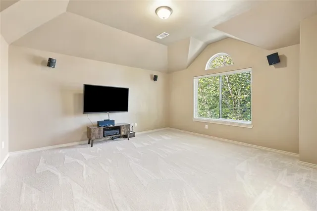 an empty room with windows and flat screen tv
