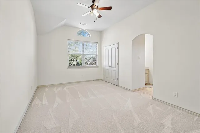 an empty room with windows and ceiling fan view