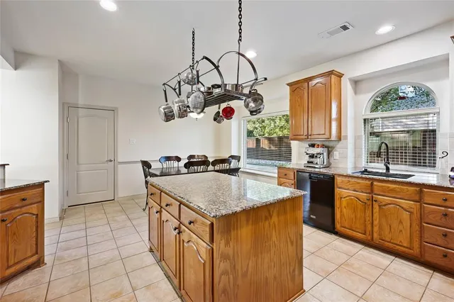 a kitchen with stainless steel appliances granite countertop a sink counter space cabinets and a window