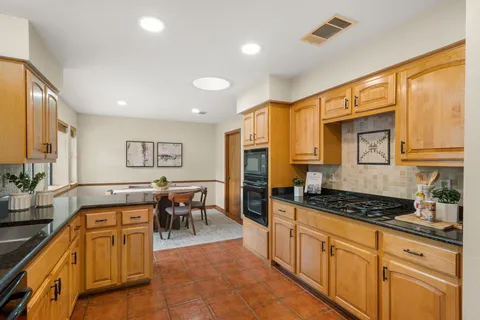 a kitchen with stainless steel appliances granite countertop a stove a sink and a refrigerator