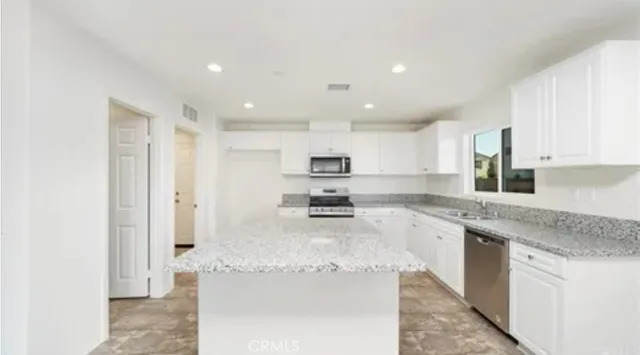 a large kitchen with stainless steel appliances granite countertop a granite counter tops and a stove