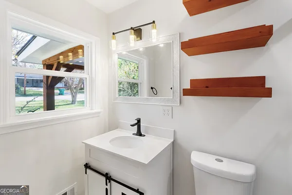 a bathroom with a sink a toilet and a window