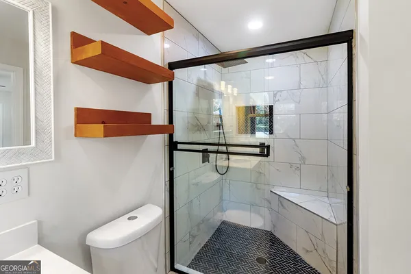 a bathroom with a toilet and a shower
