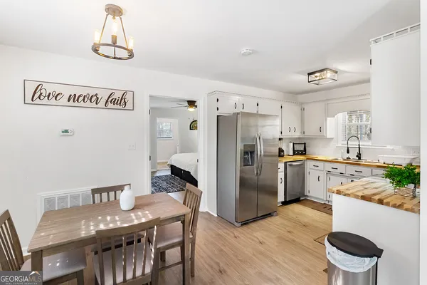 a kitchen with refrigerator and wooden floor