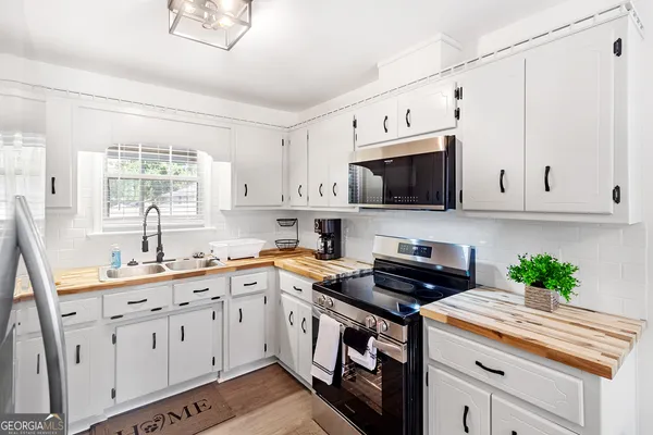 a kitchen with cabinets appliances a sink and a window
