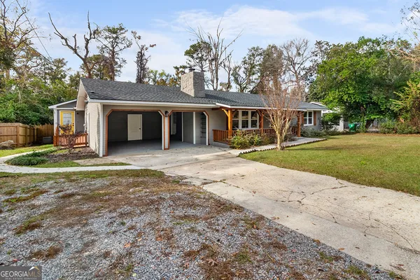 a view of a house with backyard and trees